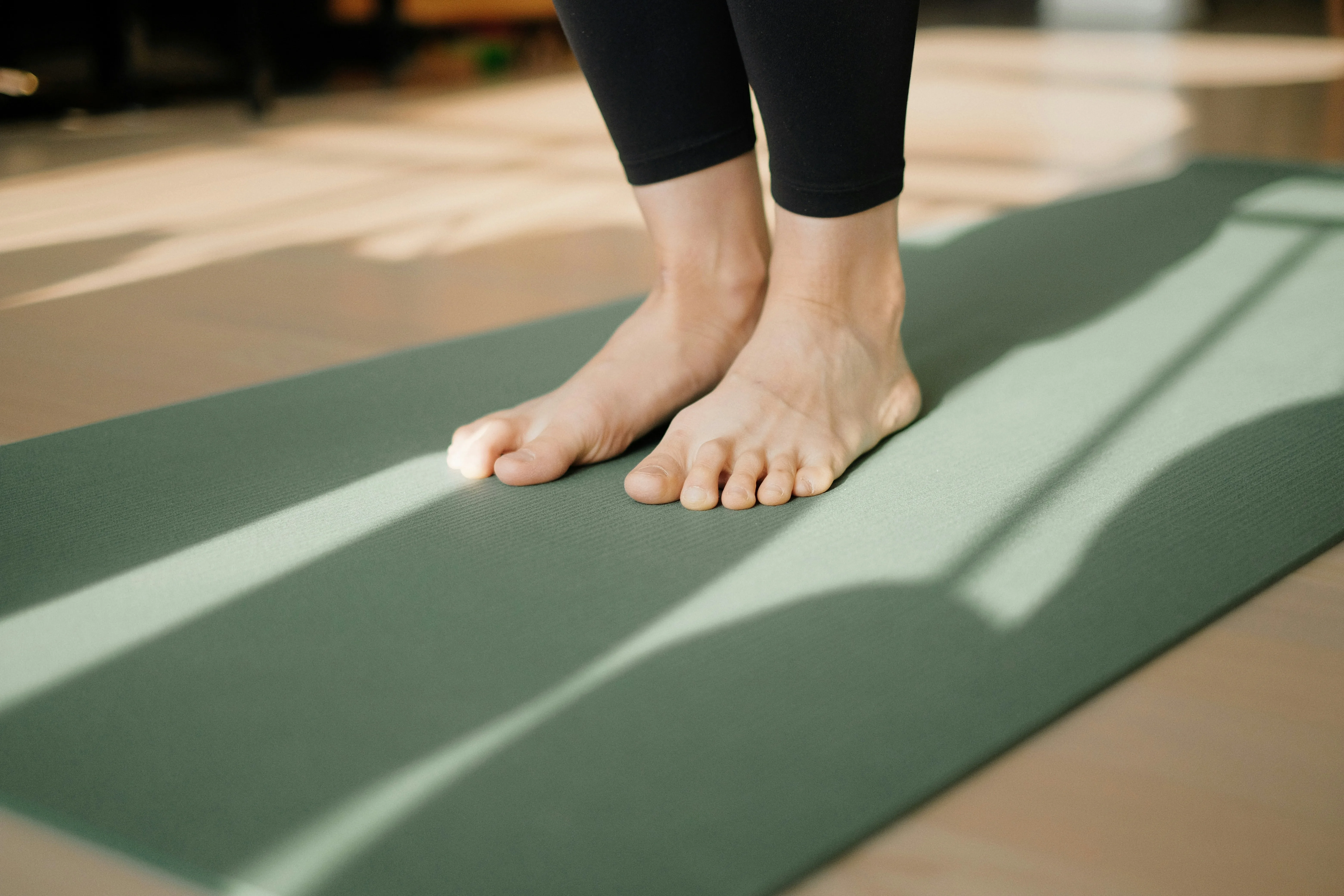 Pieds posés sur un tapis de yoga pour revenir à un appui stable pendant une séance anti-stress.